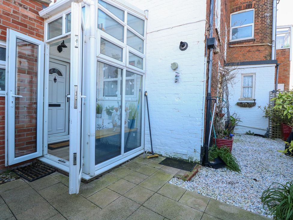A conservatory entrance with gravel and plants at Hideaway Cottage in Hunstanton