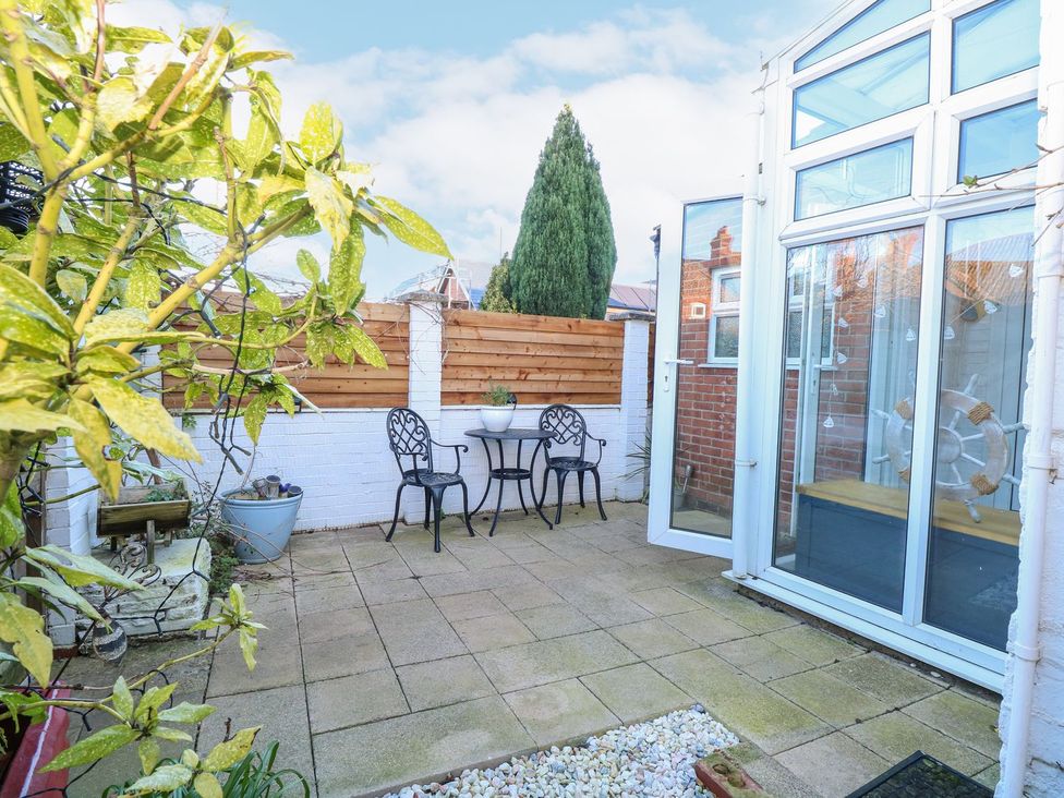 A garden with a table and chairs at Hideaway Cottage in Hunstanton