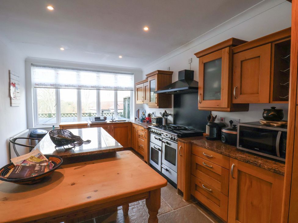 A kitchen with wooden cabinets and appliances at 11 Peasholm Avenue in Scarborough