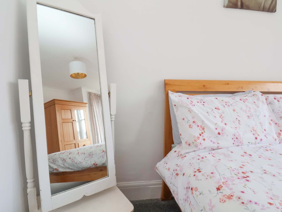 A bedroom with a bed and mirror at 11 Peasholm Avenue in Scarborough