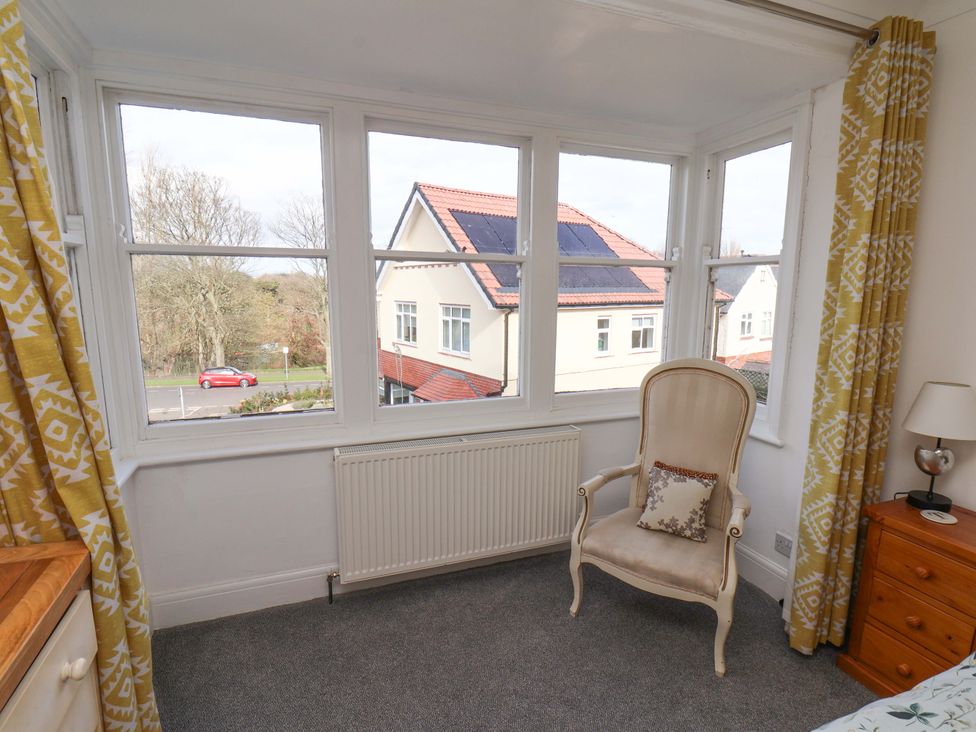A bedroom with a window and chair at 11 Peasholm Avenue Scarborough