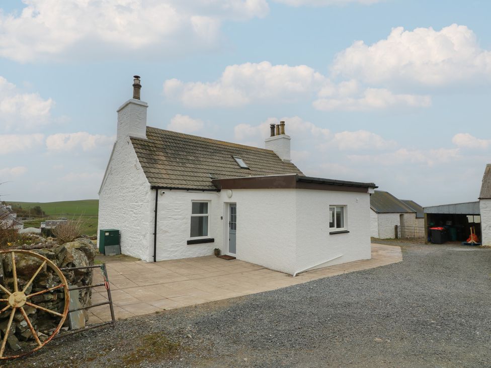 A cottage with a white exterior and patio at South Kirklauchline Farm Stoneykirk near Sandhead