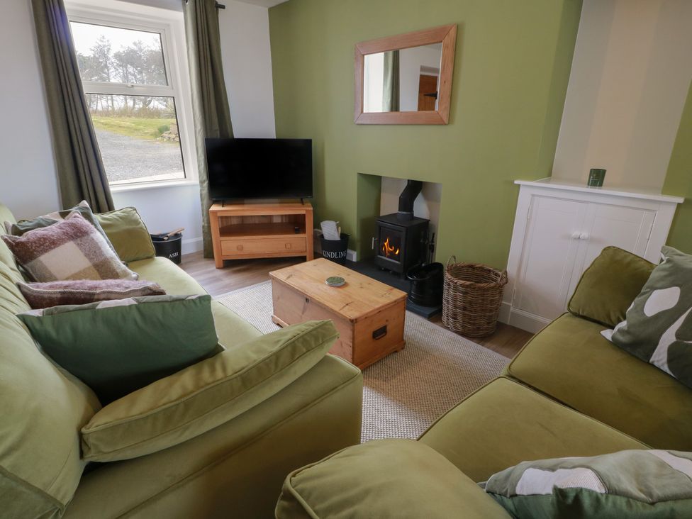 A living room with a television and a fireplace at South Kirklauchline Farm Stoneykirk near Sandhead