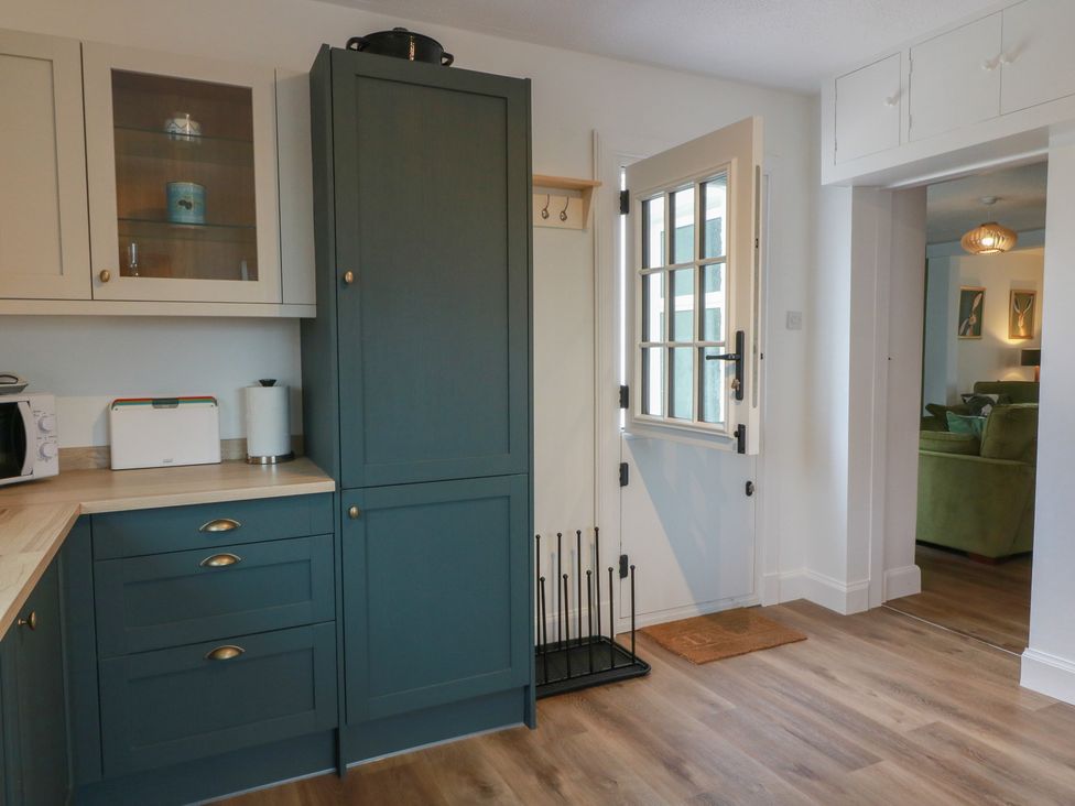 A kitchen with cabinets and a door at South Kirklauchline Farm Stoneykirk near Sandhead