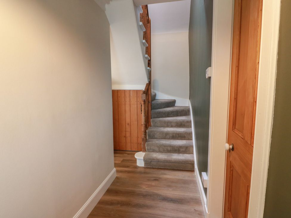 A hallway with a staircase and door at South Kirklauchline Farm Stoneykirk near Sandhead