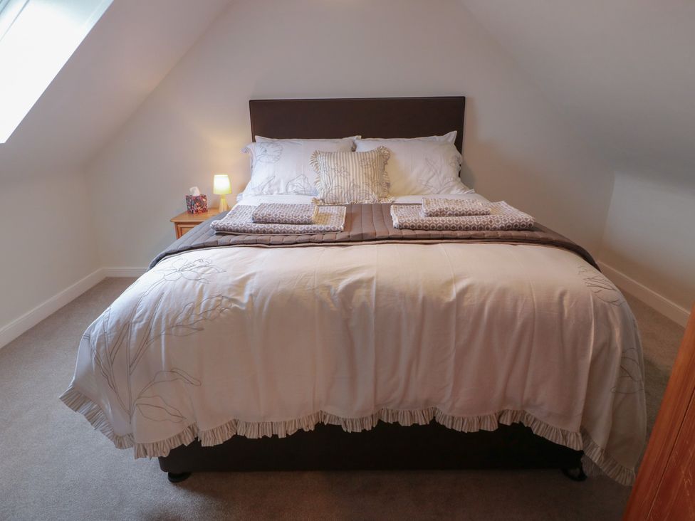 A bedroom with a bed and bedside lamp at South Kirklauchline Farm Stoneykirk near Sandhead