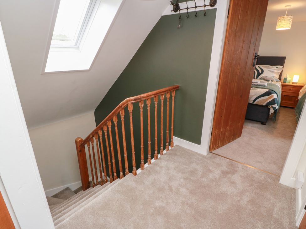 A hallway with stairs and a door leading to a bedroom at South Kirklauchline Farm Stoneykirk near Sandhead