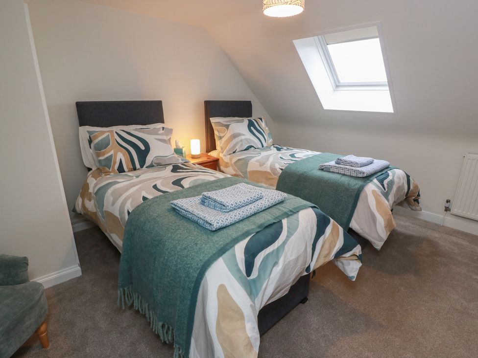 A bedroom with two beds and a window at South Kirklauchline Farm Stoneykirk near Sandhead