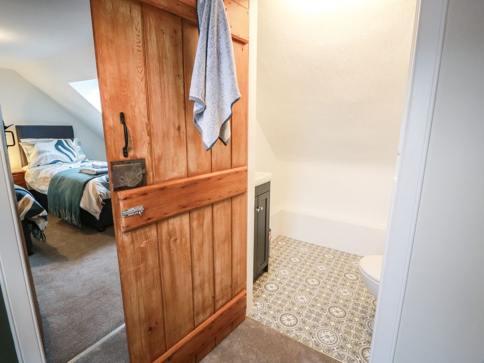 A bathroom with a door leading to a bedroom at South Kirklauchline Farm Stoneykirk near Sandhead