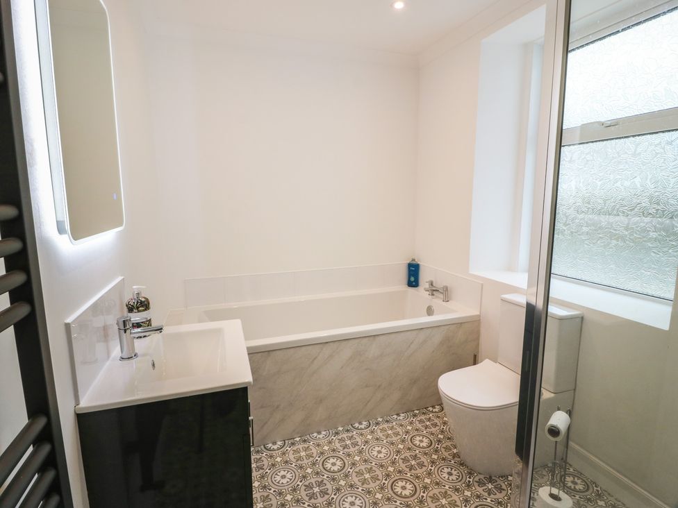 A bathroom with a bathtub, toilet, sink, and shower enclosure at South Kirklauchline Farm, Stoneykirk near Sandhead
