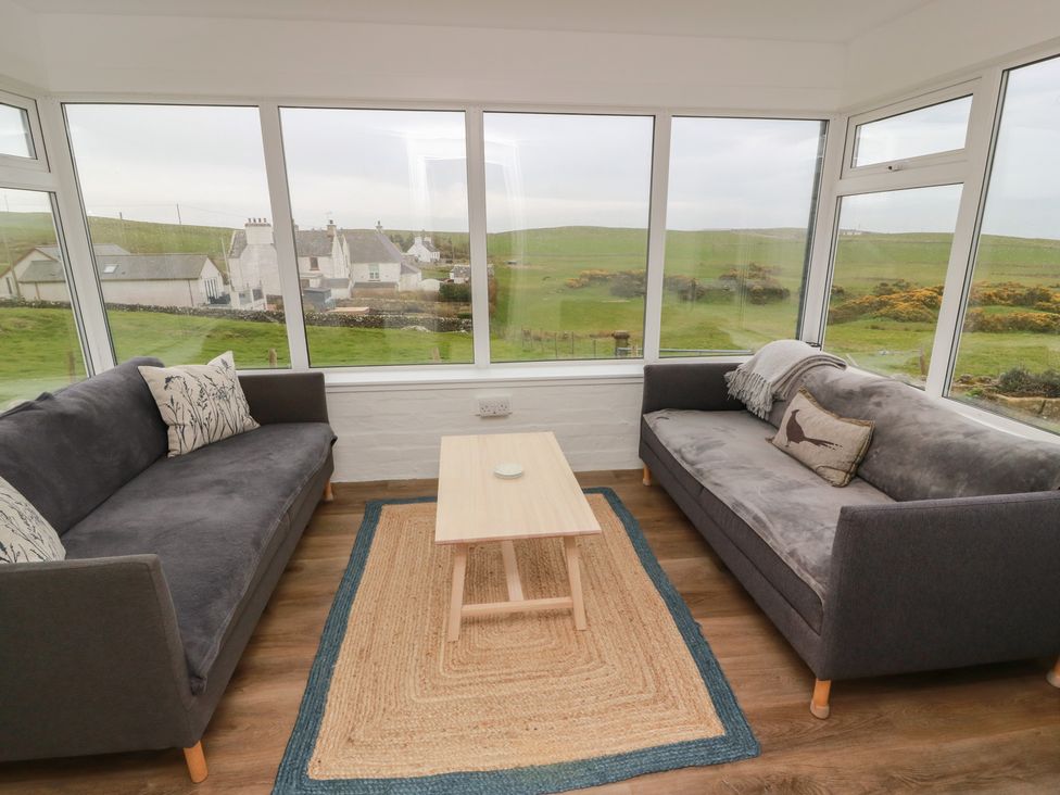 A conservatory with sofas and a coffee table at South Kirklauchline Farm Stoneykirk near Sandhead