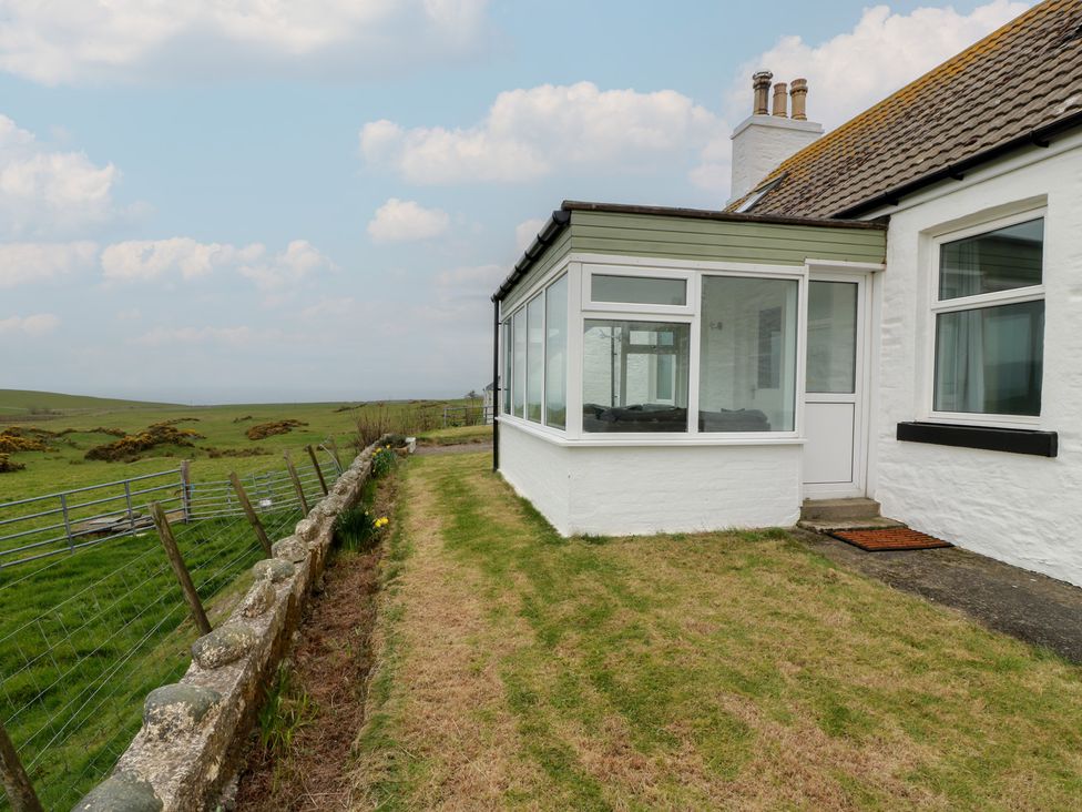 An outdoor view of a house with a conservatory at South Kirklauchline Farm Stoneykirk near Sandhead