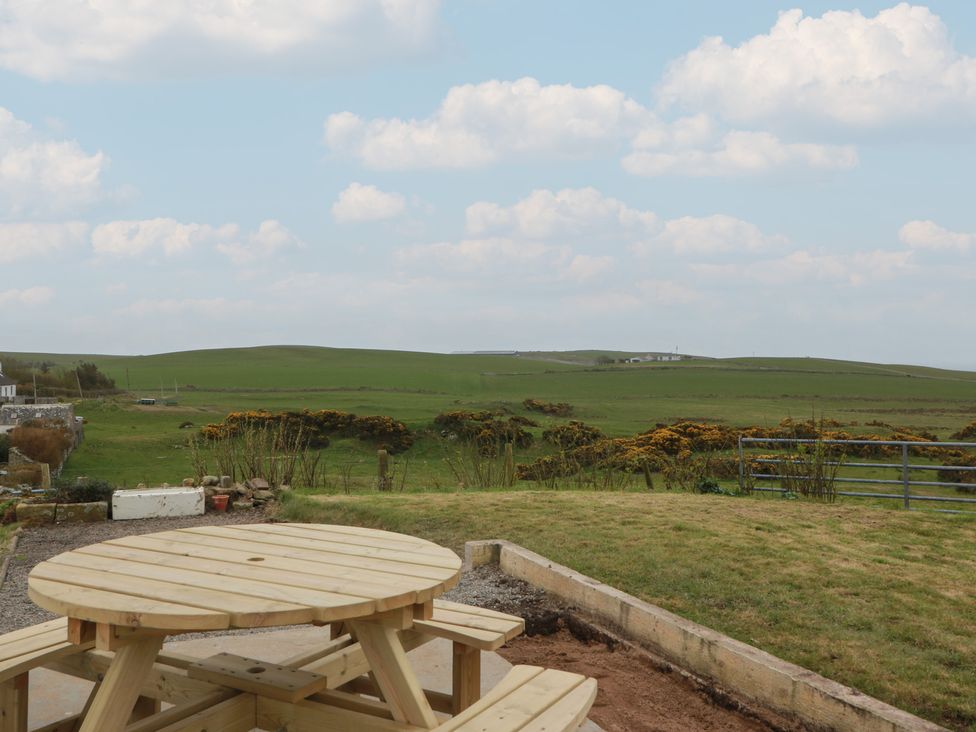 An outdoor area with a wooden table and grass at South Kirklauchline Farm, Stoneykirk near Sandhead