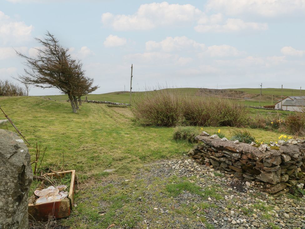 A garden with grass and a stone wall at South Kirklauchline Farm Stoneykirk near Sandhead