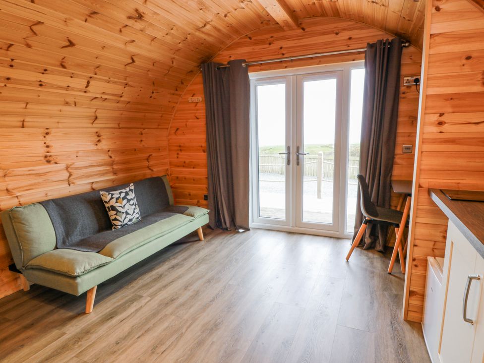 A living room with a sofa and doorway at Keith in Stoneykirk near Sandhead