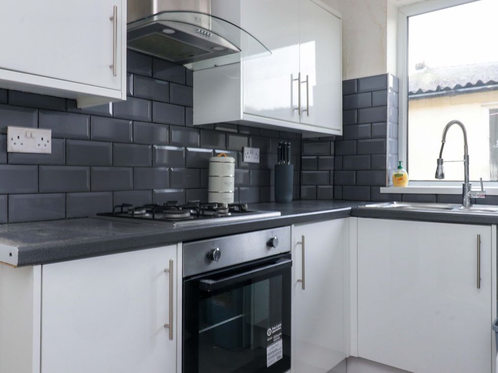 A kitchen with a gas stove, sink, and cabinets at 46 Marlborough Road, Accrington