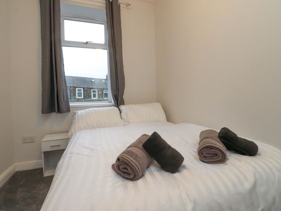 A bedroom with a bed and towels on it at 46 Marlborough Road in Accrington