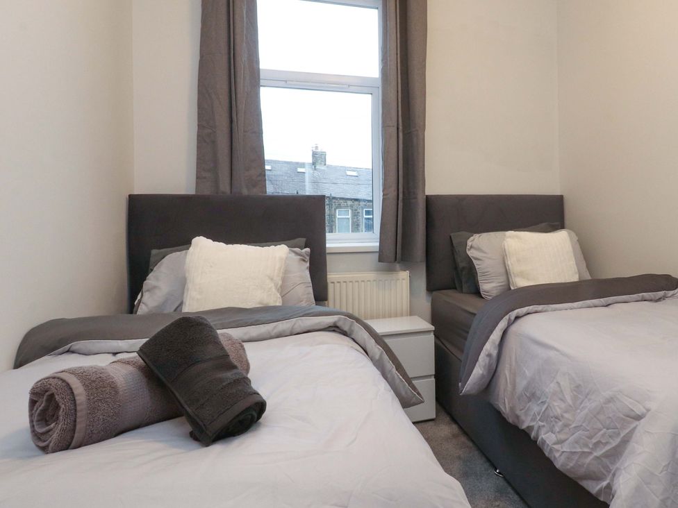 A bedroom with two beds and a window at 46 Marlborough Road Accrington