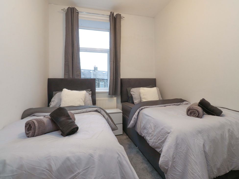 A bedroom with two beds and towels at 46 Marlborough Road Accrington