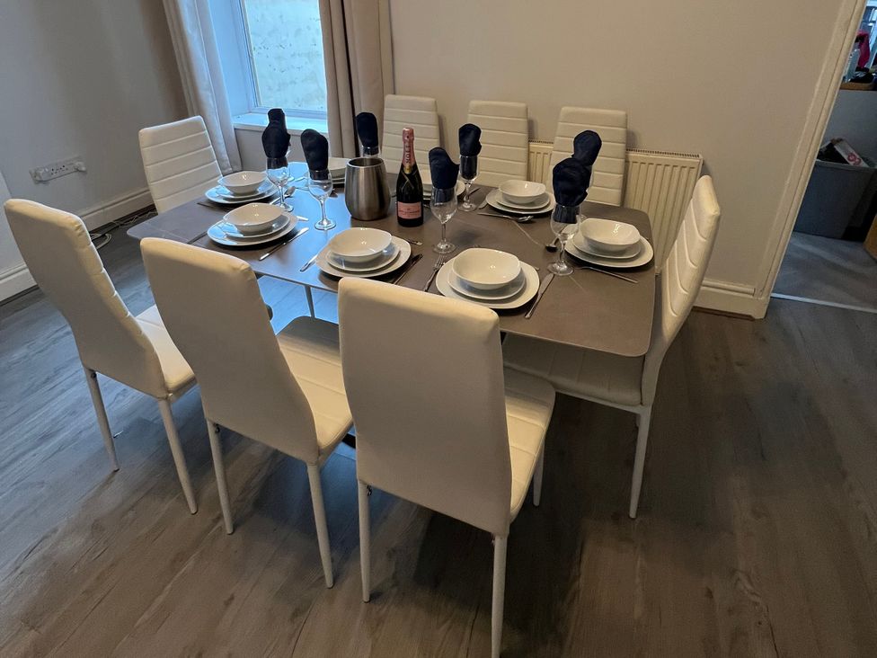 A dining room with a table set for eight at 46 Marlborough Road Accrington