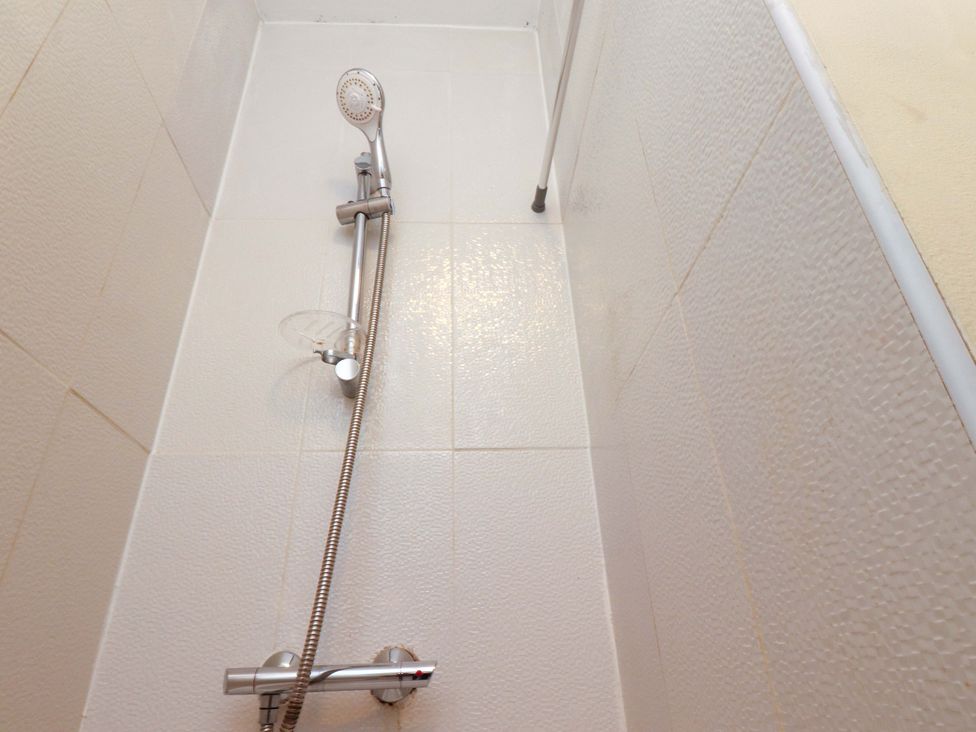 A shower area with a showerhead and controls at Victoria Place in Accrington
