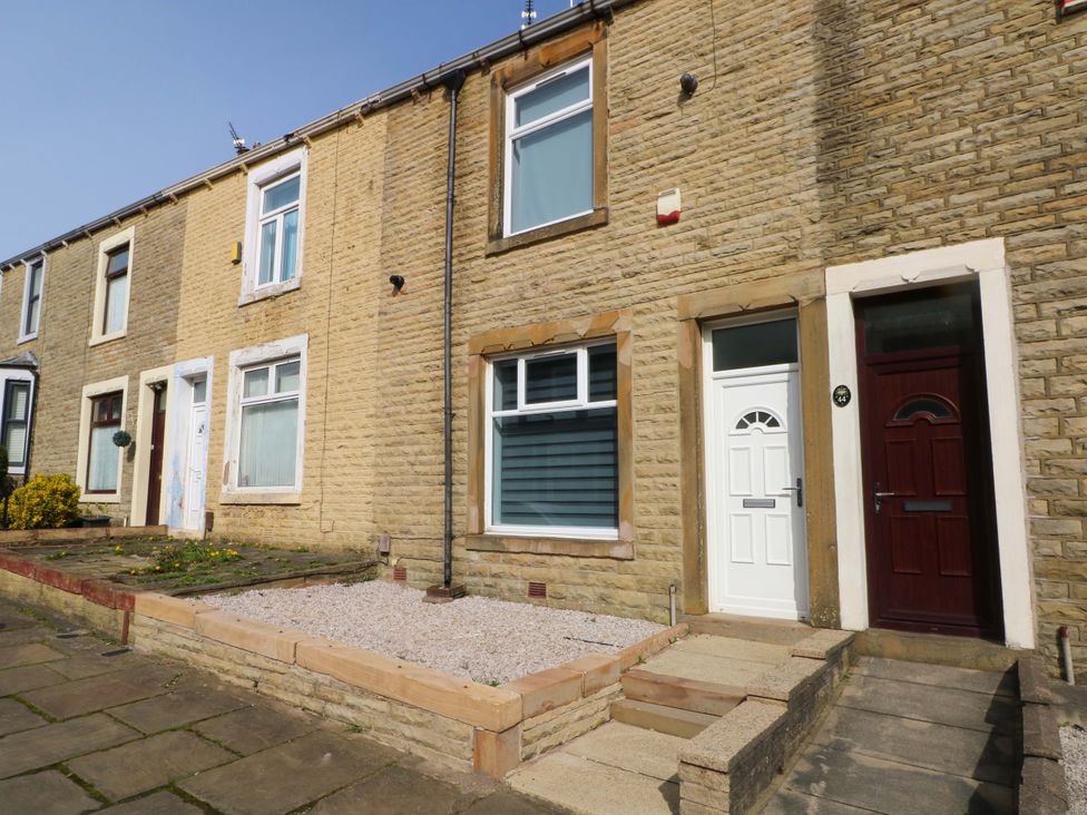 A front view of stone houses with steps and doors at Victoria Place in Accrington