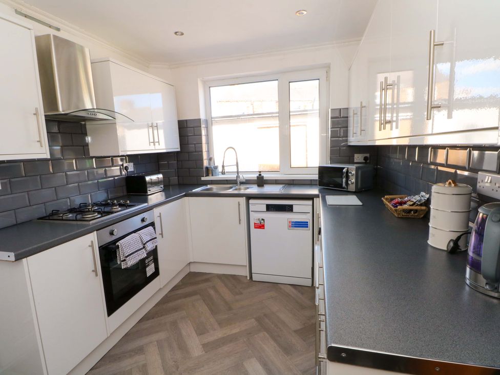 A kitchen with appliances and a window at Victoria Place in Accrington