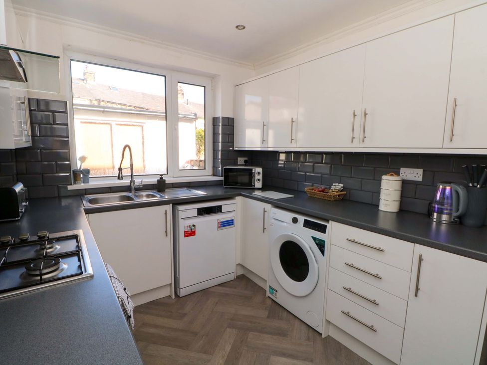A kitchen with appliances and a window at Victoria Place Accrington