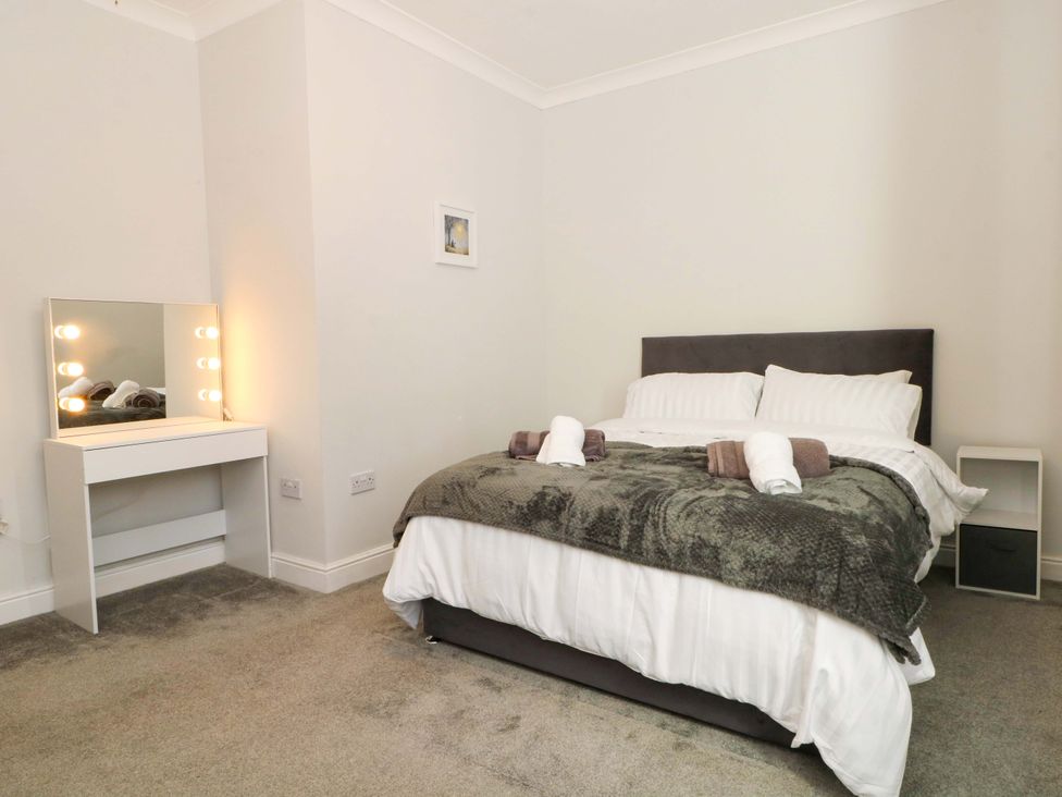 A bedroom with a bed and a vanity mirror at Victoria Place in Accrington