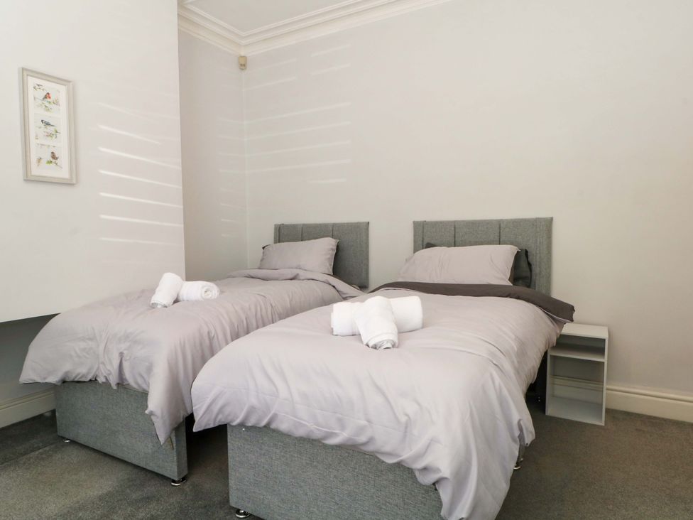 A bedroom with two twin beds and a nightstand at Victoria Place in Accrington