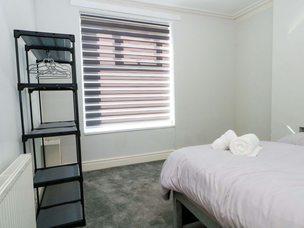 A bedroom with a bed and shelf at Victoria Place in Accrington