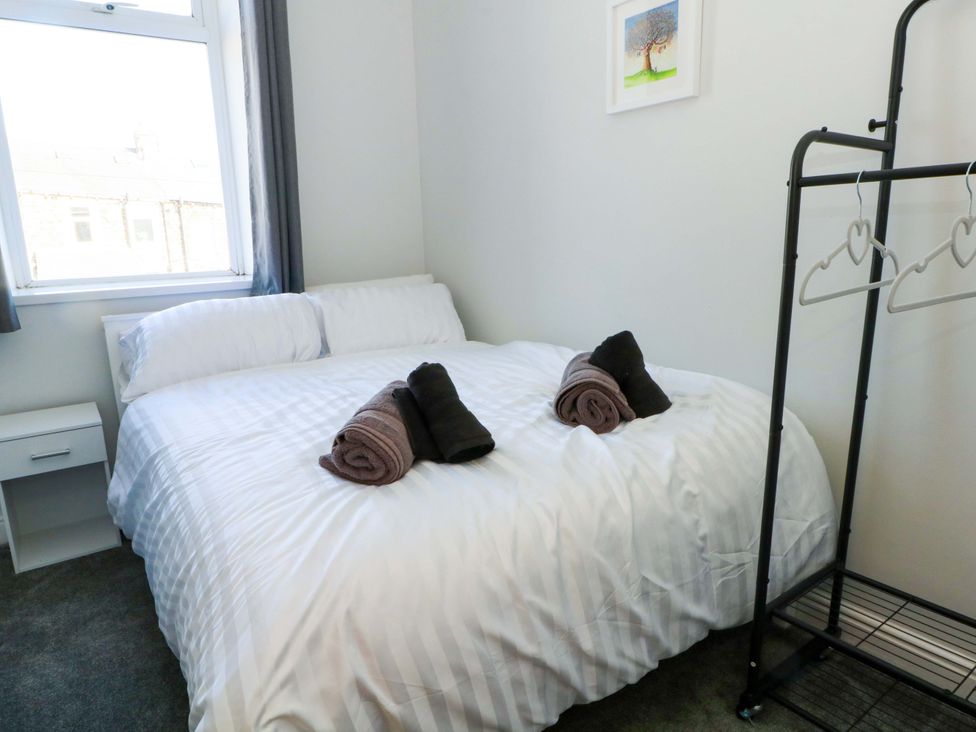 A bedroom with bed and towels arranged at Victoria Place in Accrington