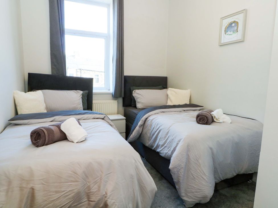 A bedroom with two beds and a window at Victoria Place in Accrington