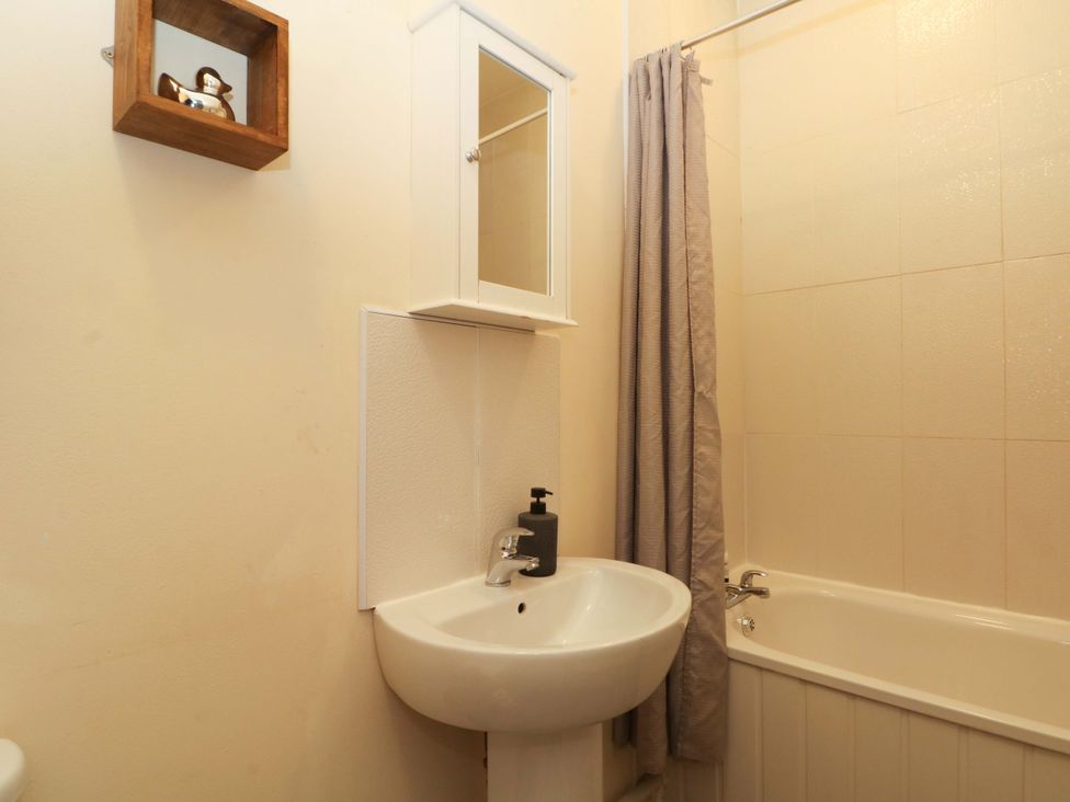 A bathroom with sink, mirror, and bathtub at Victoria Place in Accrington