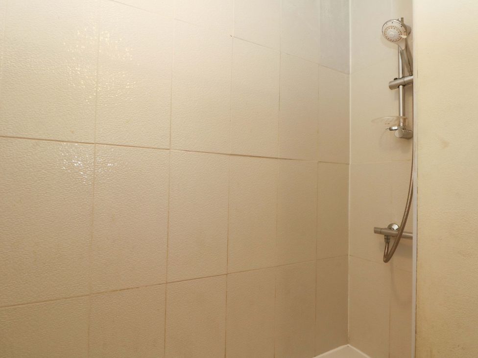 A shower area with tiles and a showerhead at Victoria Place in Accrington
