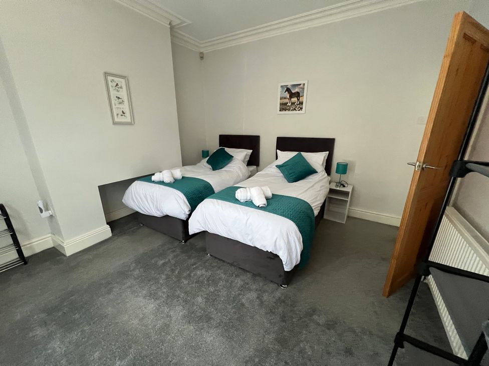 A bedroom with twin beds and bedside table at Victoria Place in Accrington