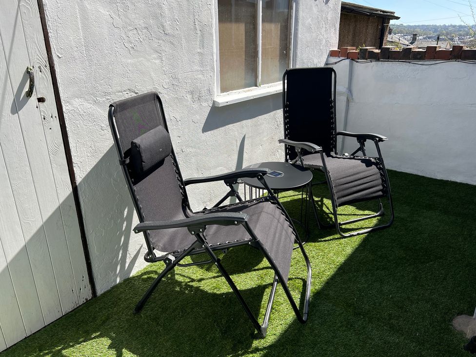 Two chairs and a side table in an outdoor area at Victoria Place in Accrington
