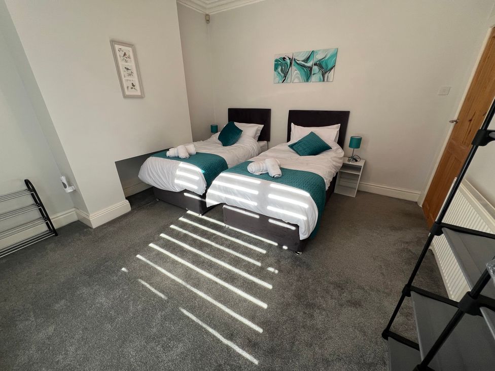 A bedroom with twin beds and a bedside table at Victoria Place Accrington