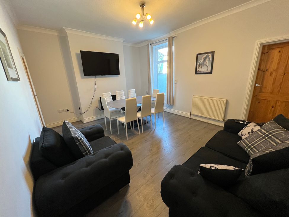 A living room with a dining table and chairs at Victoria Place in Accrington