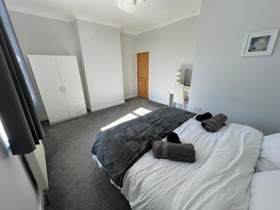 A bedroom with a bed and wardrobe at Victoria Place in Accrington
