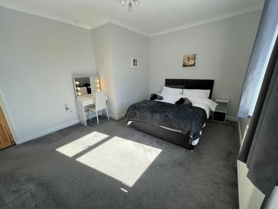 A bedroom with a bed and vanity area at Victoria Place in Accrington