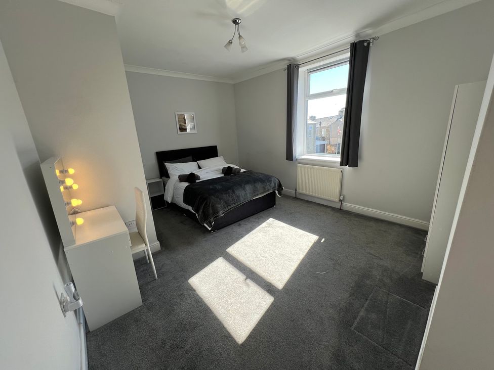 A bedroom with bed and chair at Victoria Place Accrington