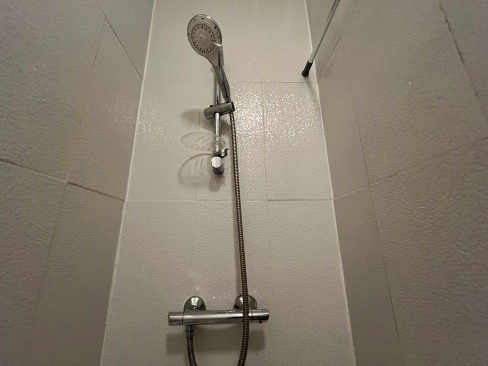 A shower unit with a shower head and control at Victoria Place in Accrington