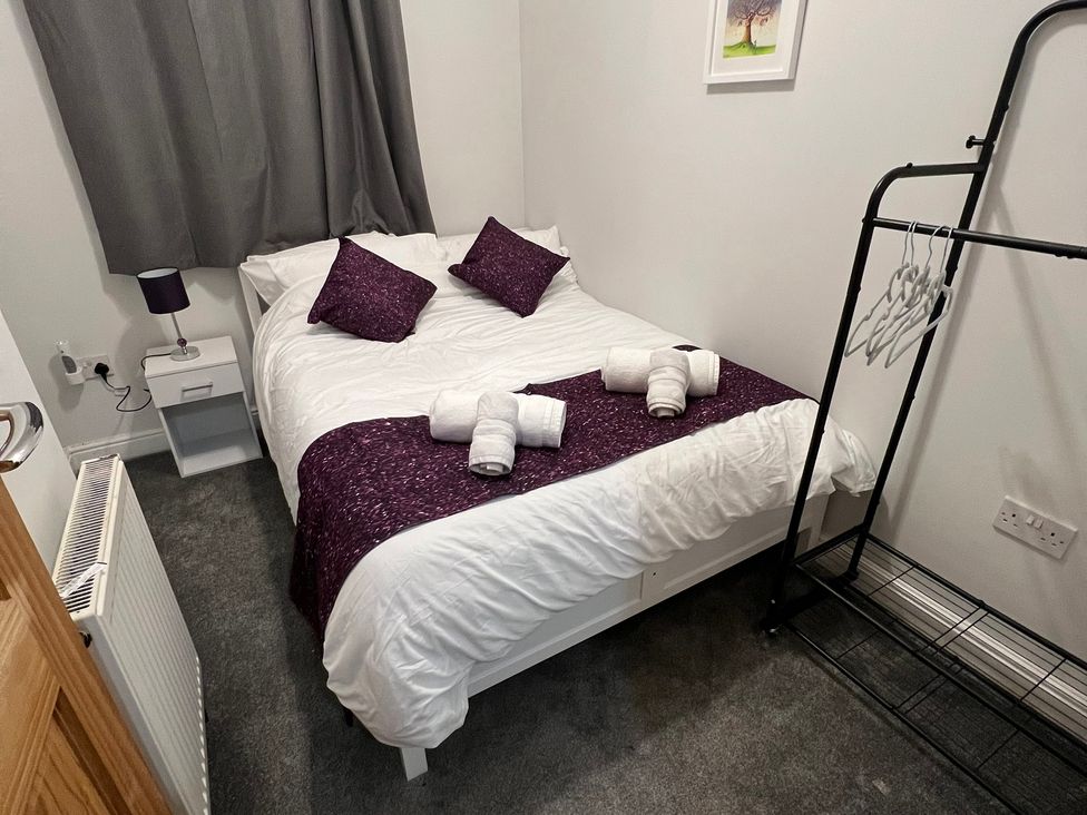 A bedroom with a bed and nightstand at Victoria Place in Accrington