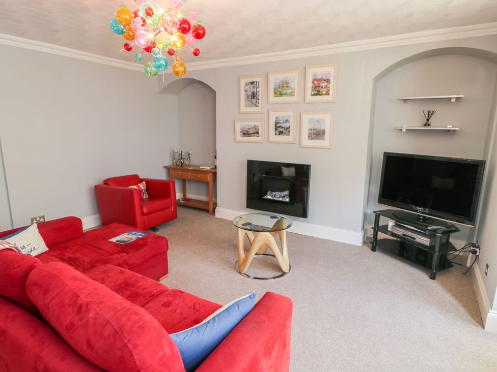 A living room with a television and seating area at The Hideaway in Whitby