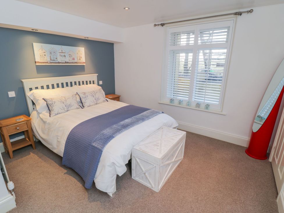 A bedroom with a bed and nightstand at The Hideaway in Whitby