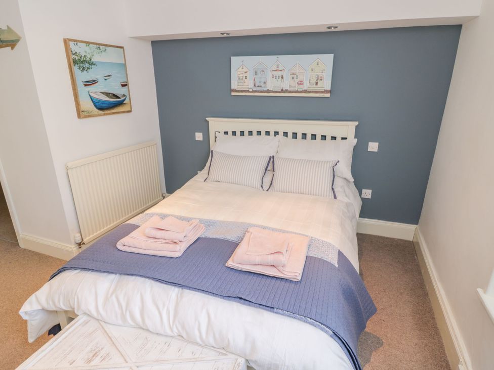 A bedroom with a bed and wall art at The Hideaway in Whitby