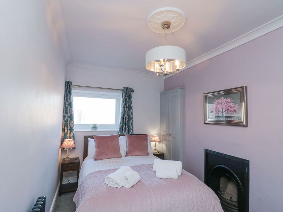 A bedroom with a bed and bedside lamp at Cuckoo's Nest in Whitby
