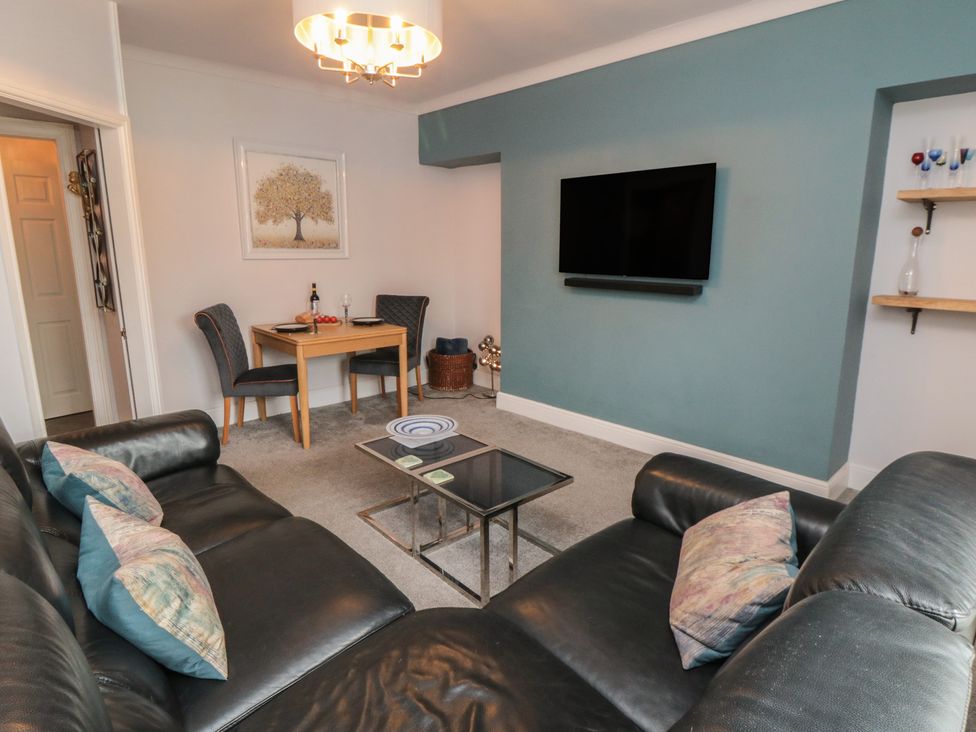 A living room with a sofa and dining table at Cuckoo's Nest in Whitby