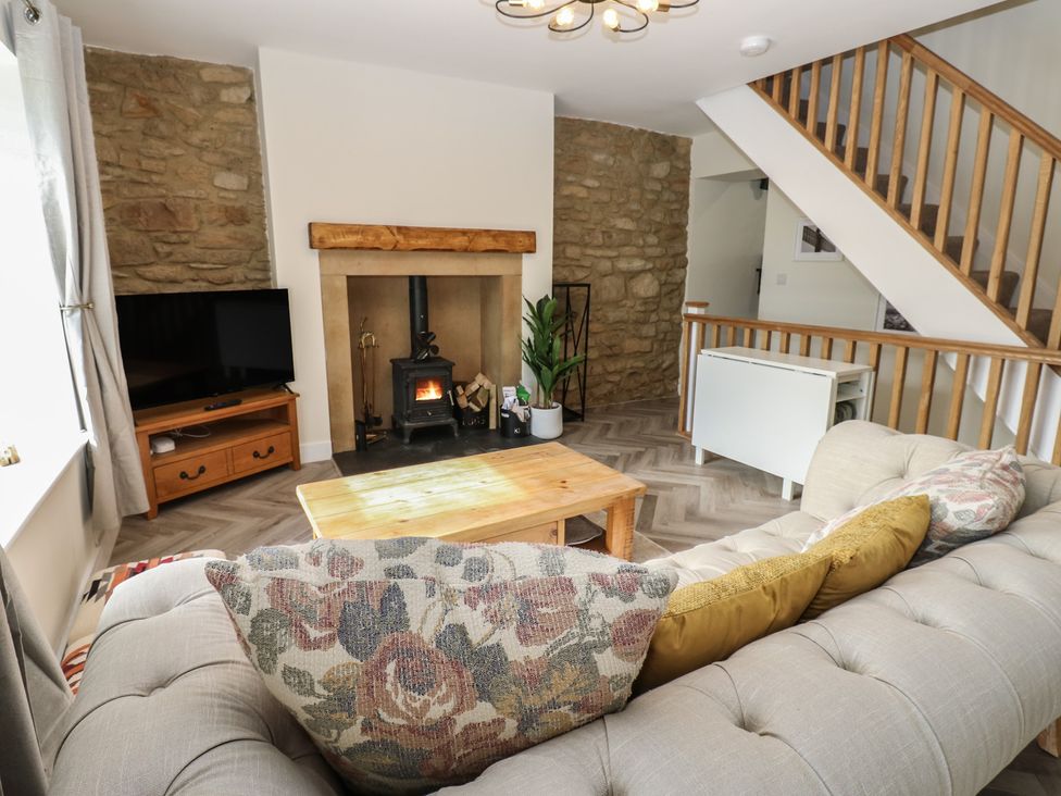 A living room with a fireplace and television at 2 Low Road